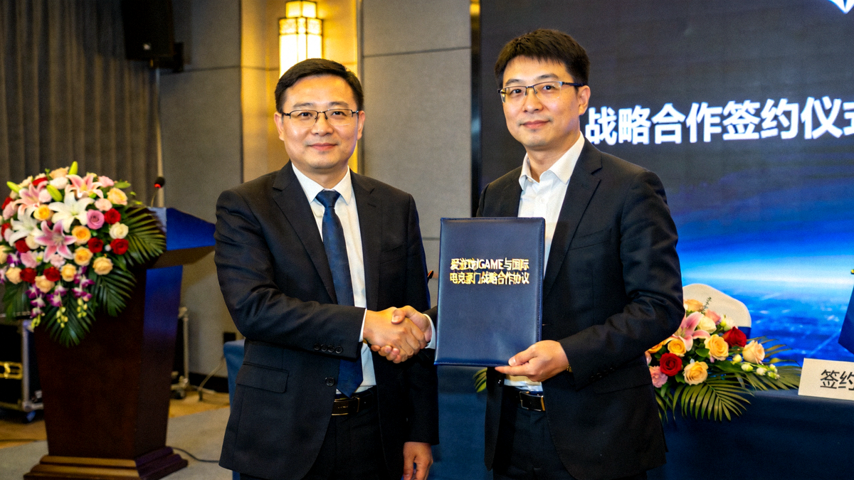 爱游戏IGAME平台与国际电竞豪门战略合作签约仪式现场，双方代表握手并展示合作文件